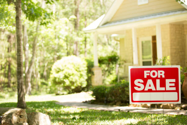 Home for sale with real estate sign in spring or summer season