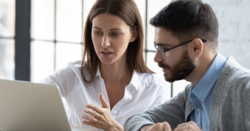 two colleagues looking at data on a laptop