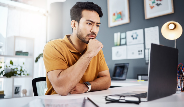 frustrated-looking man working remotely - AI initiatives