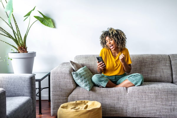 happy woman sitting on a sofa-min - telcom growth